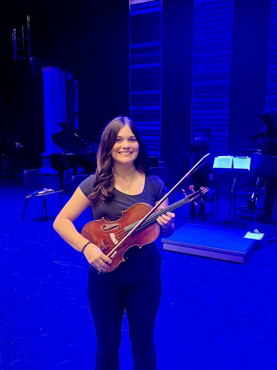 Ella holding her viola on stage